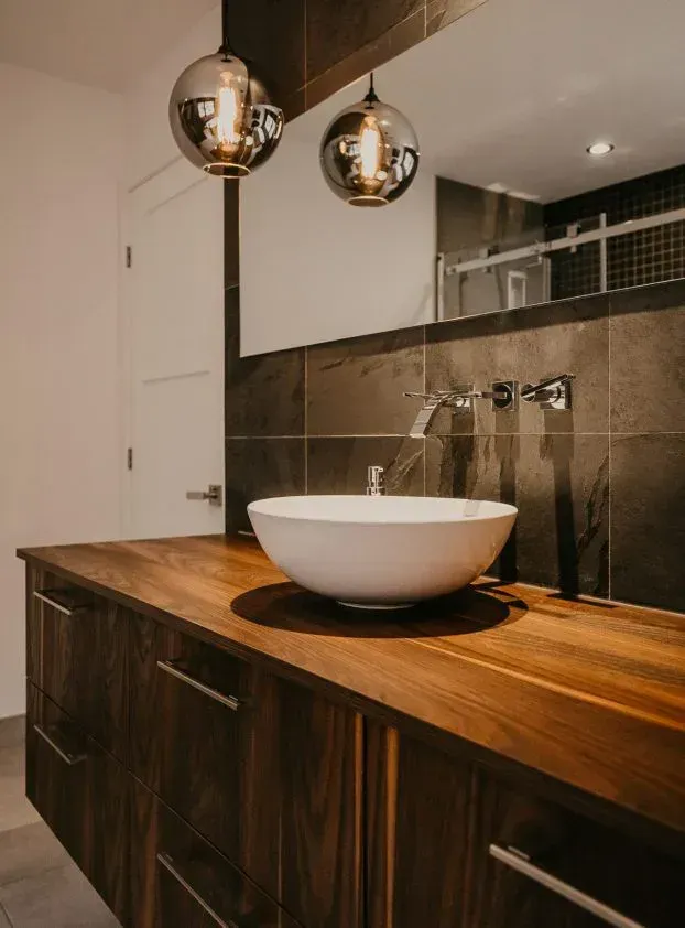 A bathroom with a wooden counter top and a sink