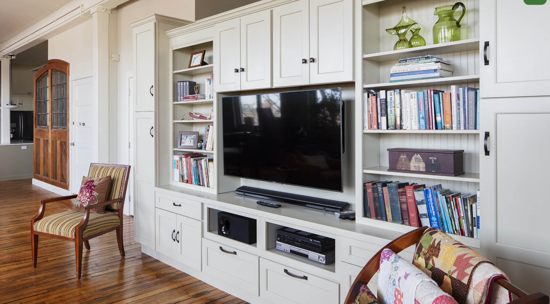 A living room with a large flat screen tv on a entertainment center.