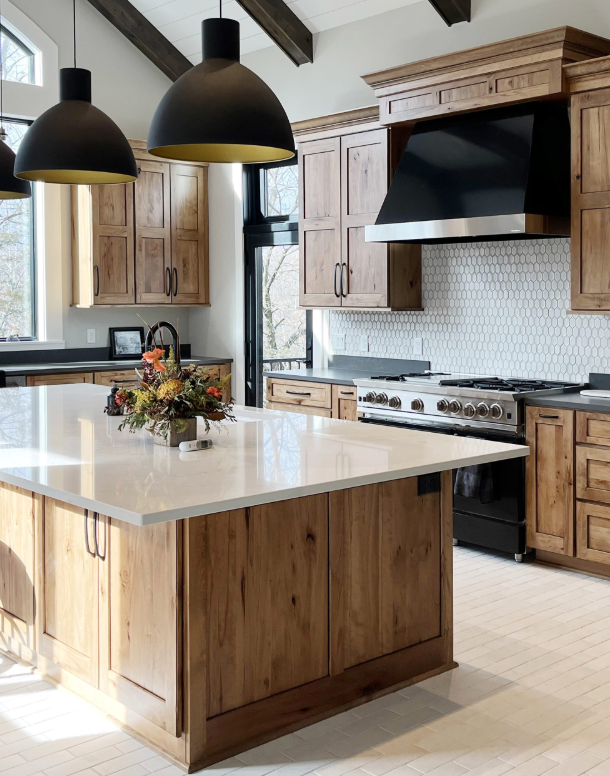 A kitchen with wooden cabinets and a large island