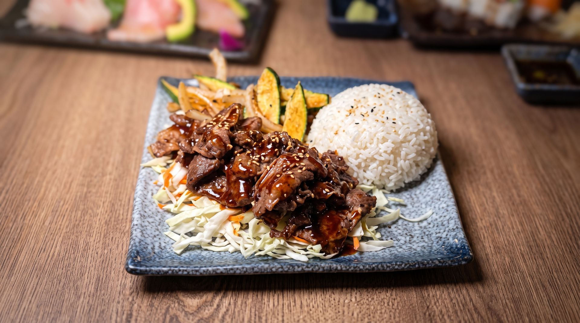 Plate of rice, fries, and shredded beef on a wooden table.