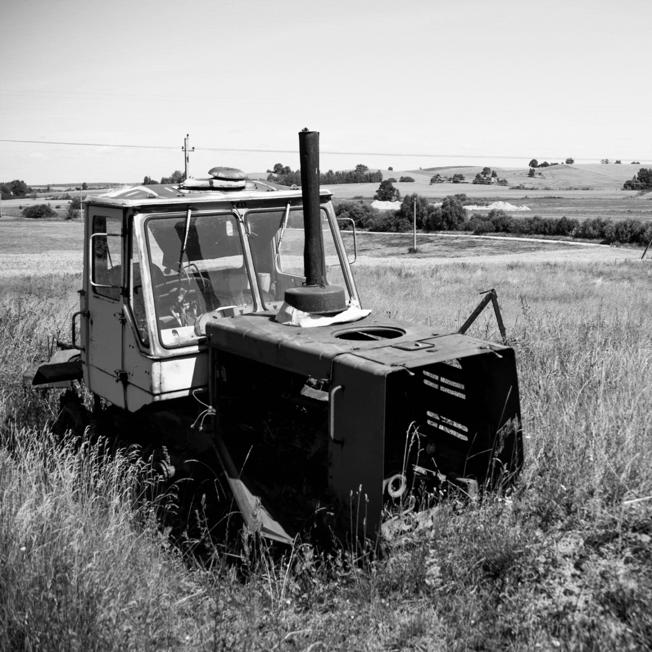 A black and white photo of an old tractor in a field