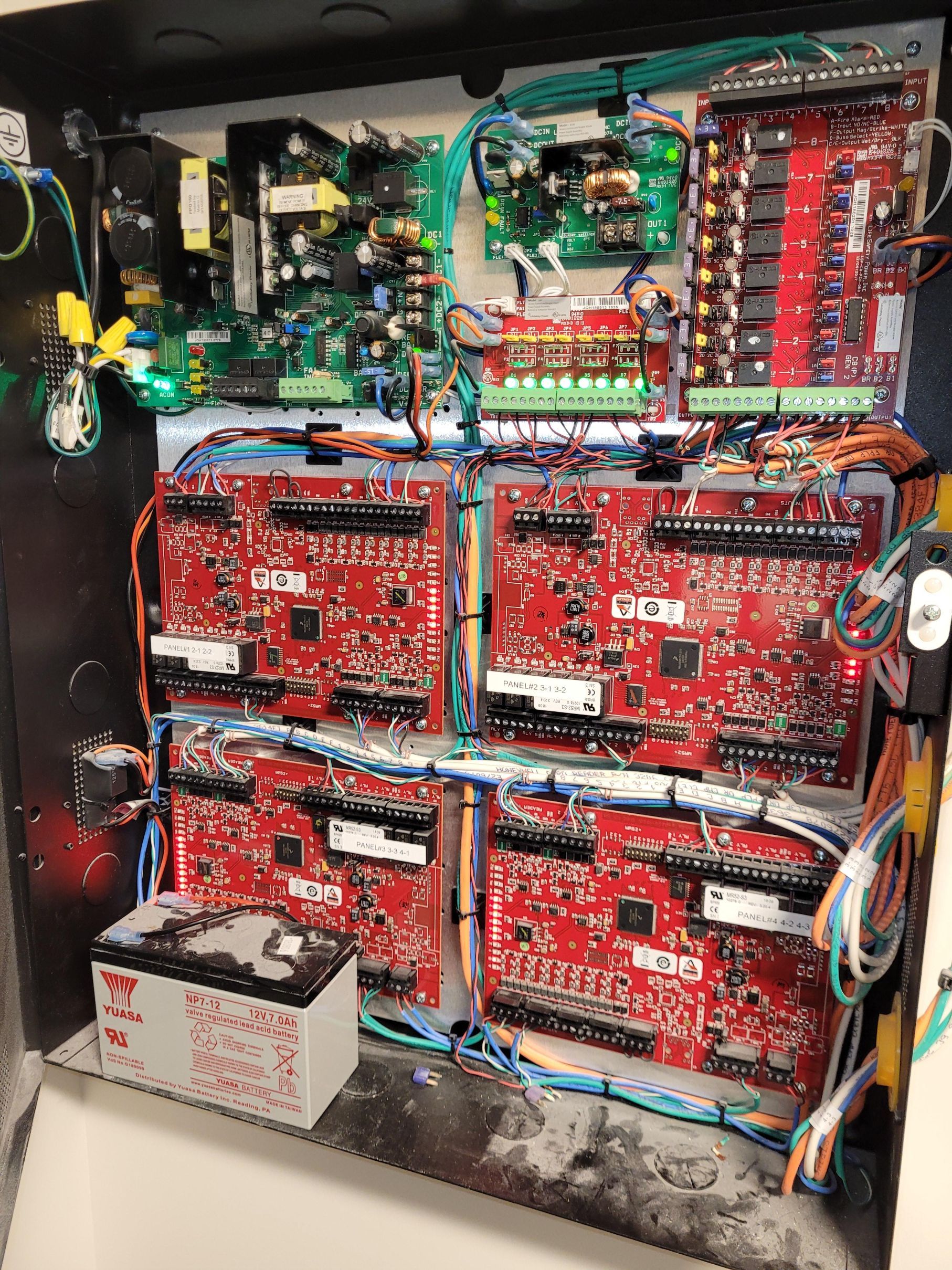 The inside of a electrical box with a lot of wires coming out of it.