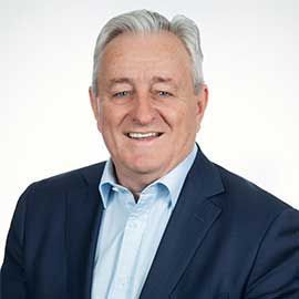 Grahame Evans in a navy suit and light blue shirt on a white background