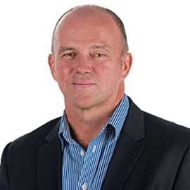 Portrait of Rob McGregor in a dark blazer and blue striped shirt on a white background
