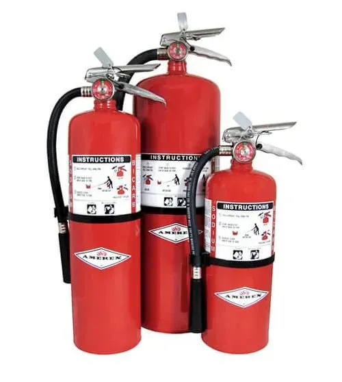 Tres extintores rojos con mangueras negras y asas plateadas sobre un fondo blanco.