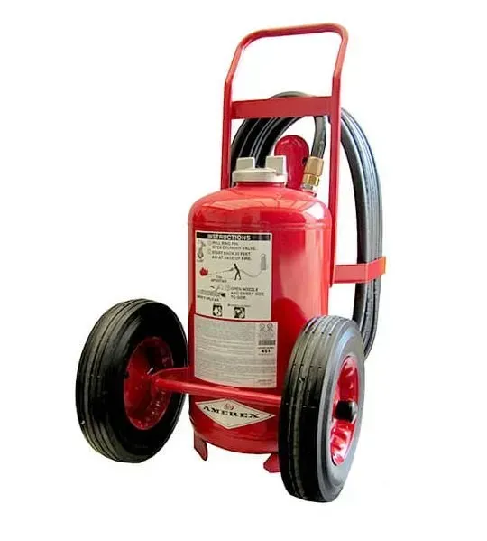 Extintor de incendios rojo con ruedas sobre un carrito con mangueras negras y un asa.