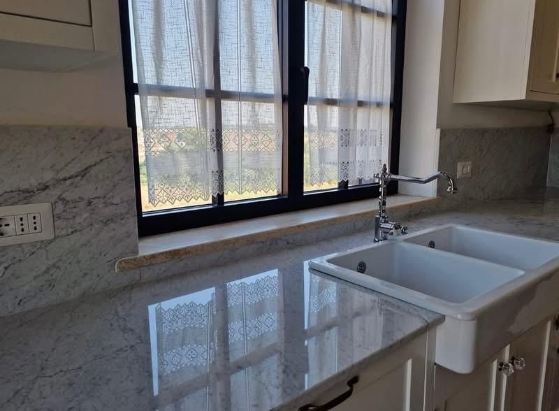 Cucina moderna con piano di lavoro in granito, lavello in stile rustico e finestra sopra il lavello