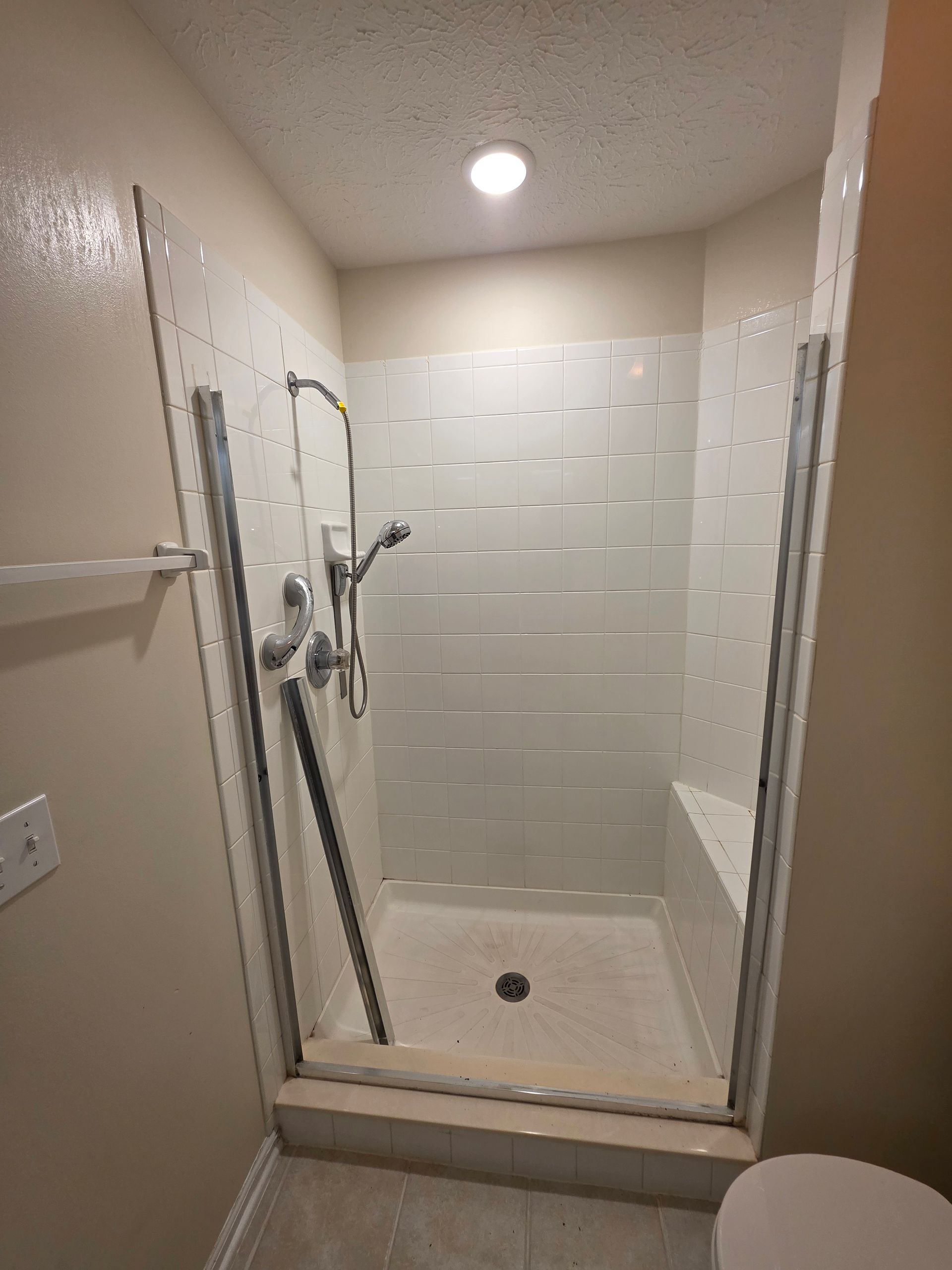 Tan and brown bathroom with a shower-tub combo, shower curtain, toilet, and dark brown walls.