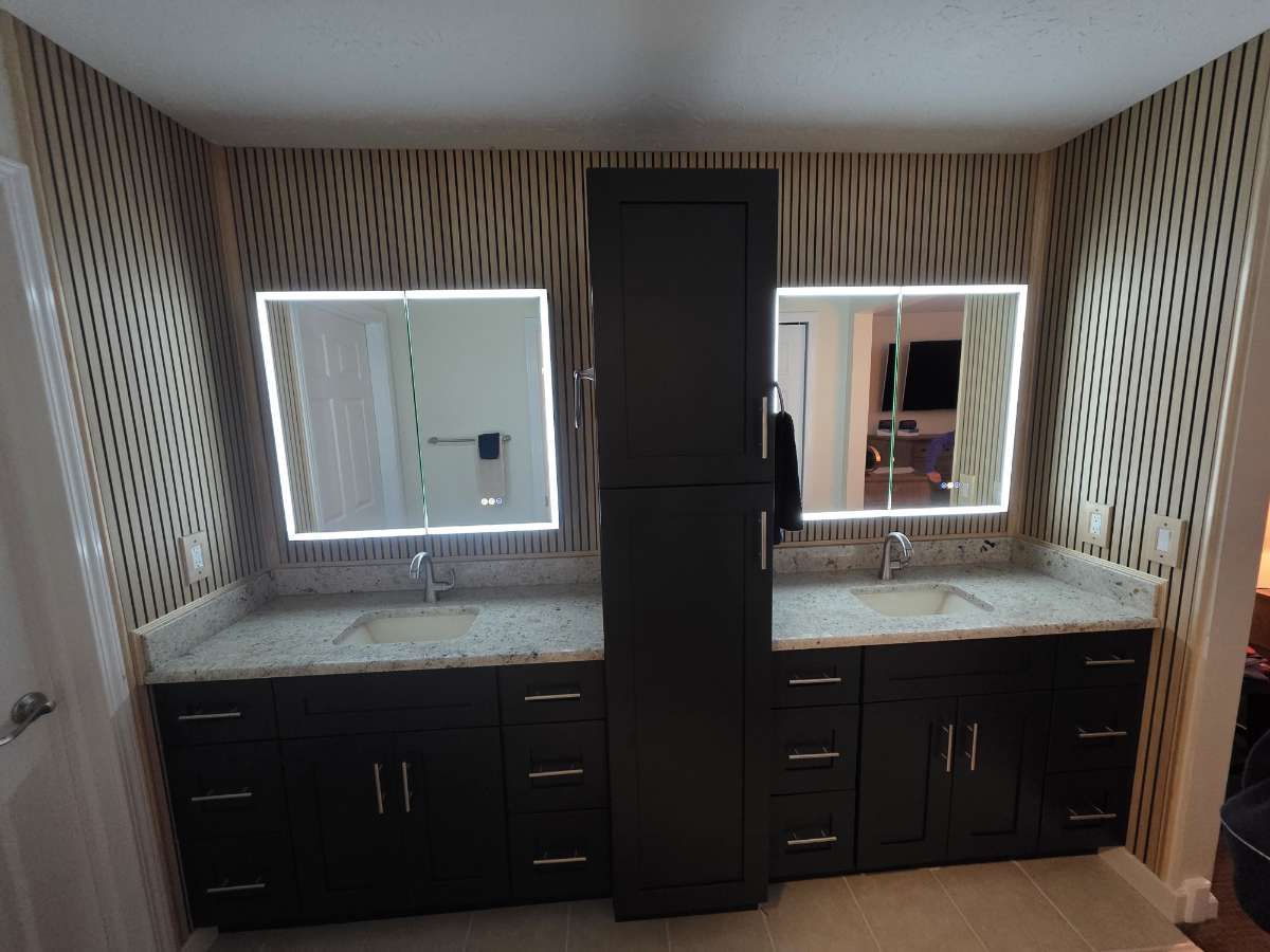 Bathroom with white cabinets, marble shower, and gray flooring.