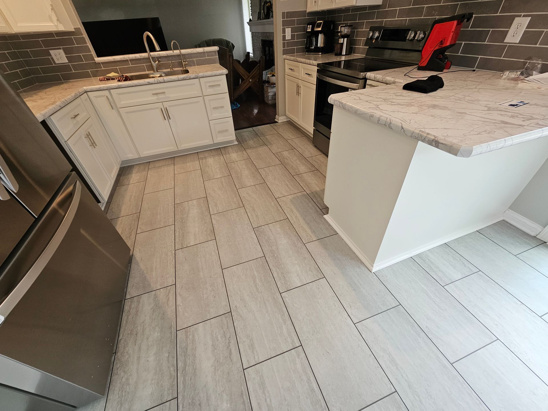 Kitchen with light gray tile floor, white cabinets, and stainless steel refrigerator.