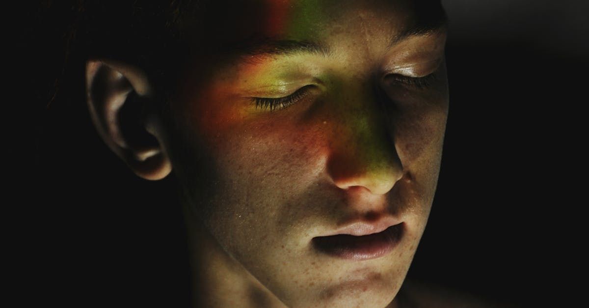 A close up of a person 's face with a rainbow projected on it.