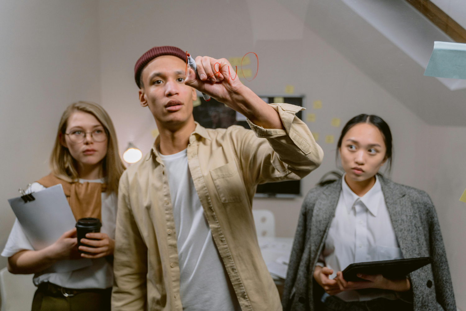 Three people in a room hold flashlights and a clipboard, looking alert.