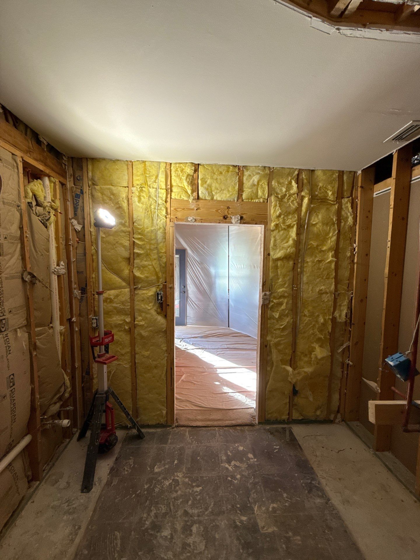 Master Bathroom under construction, with exposed framing, insulation, and doorway.