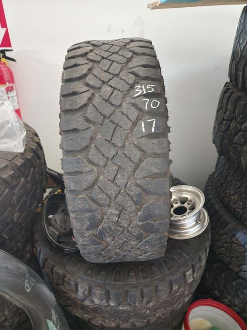 A black off-road tire with white markings