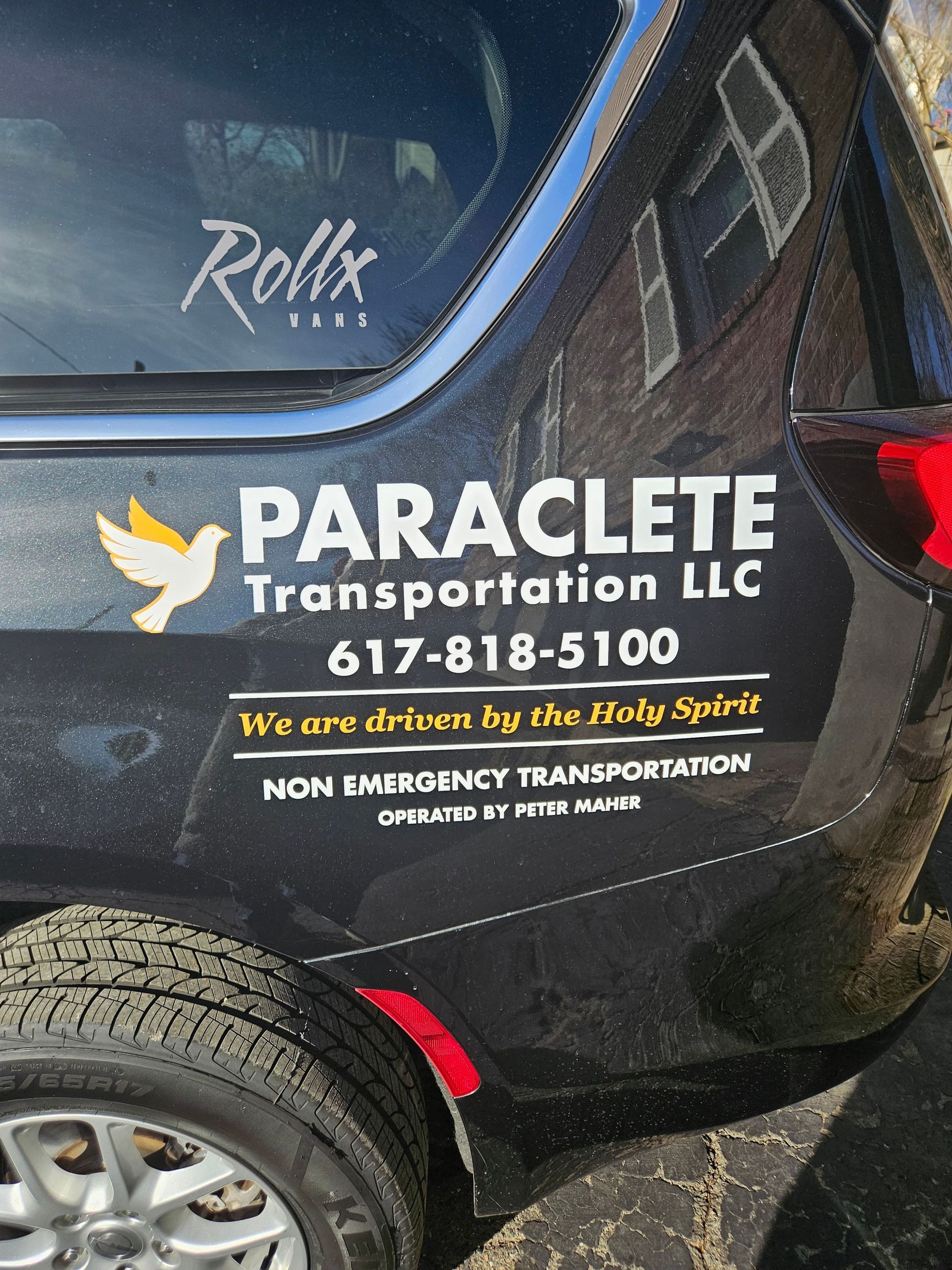 Paraclete Transportation LLC logo and contact info on a black vehicle door with a bird icon.