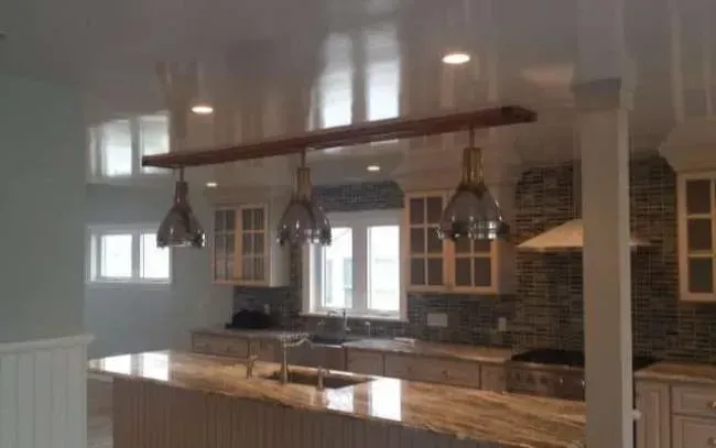 Modern kitchen with wood island, pendant lights, and brick backsplash