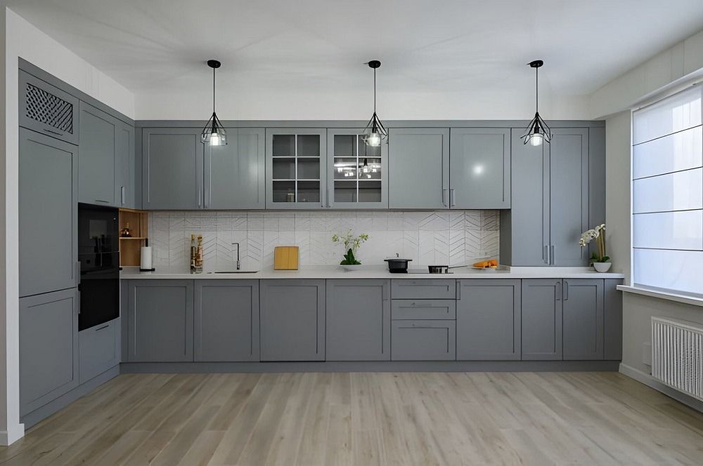 Modern gray kitchen with cabinets, island, pendant lights, and large window