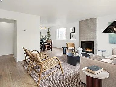 Living room with fireplace, chairs, and dining area visible in the background.