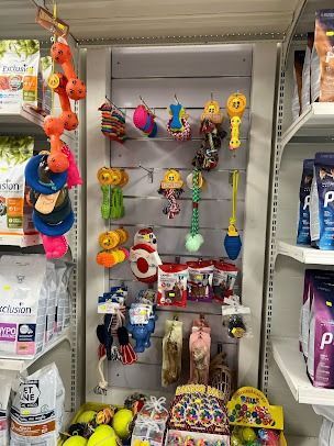 Giocattoli e snack colorati per animali domestici esposti sugli scaffali di un negozio nel reparto articoli per animali.