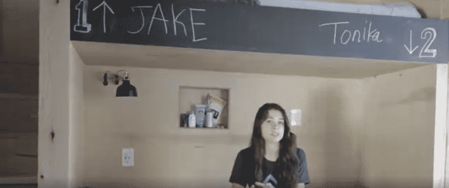 A woman stands under a sign that says