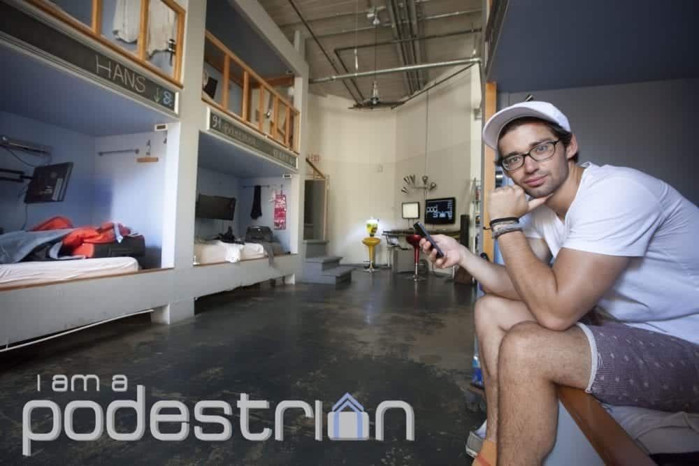 Man in a room with bunks with the text "I am a podestrian"