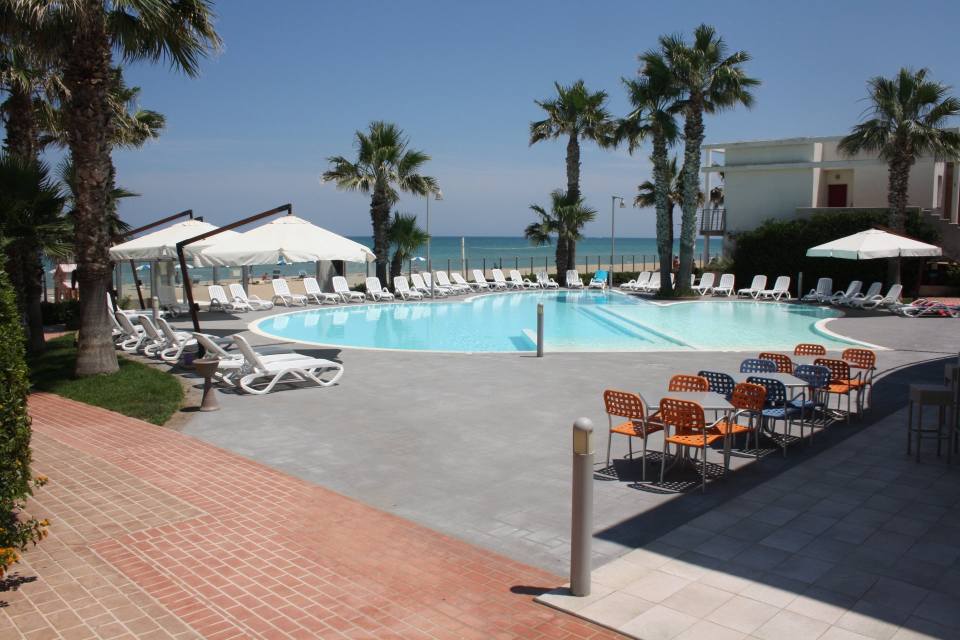Piscina con sdraio e ombrelloni