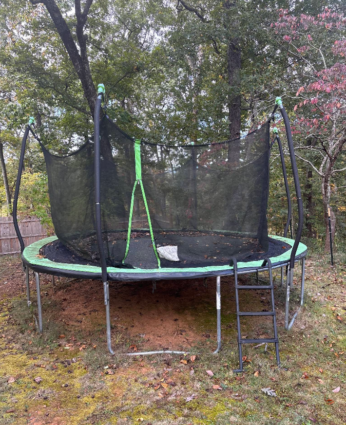 Round trampoline with safety net in backyard.