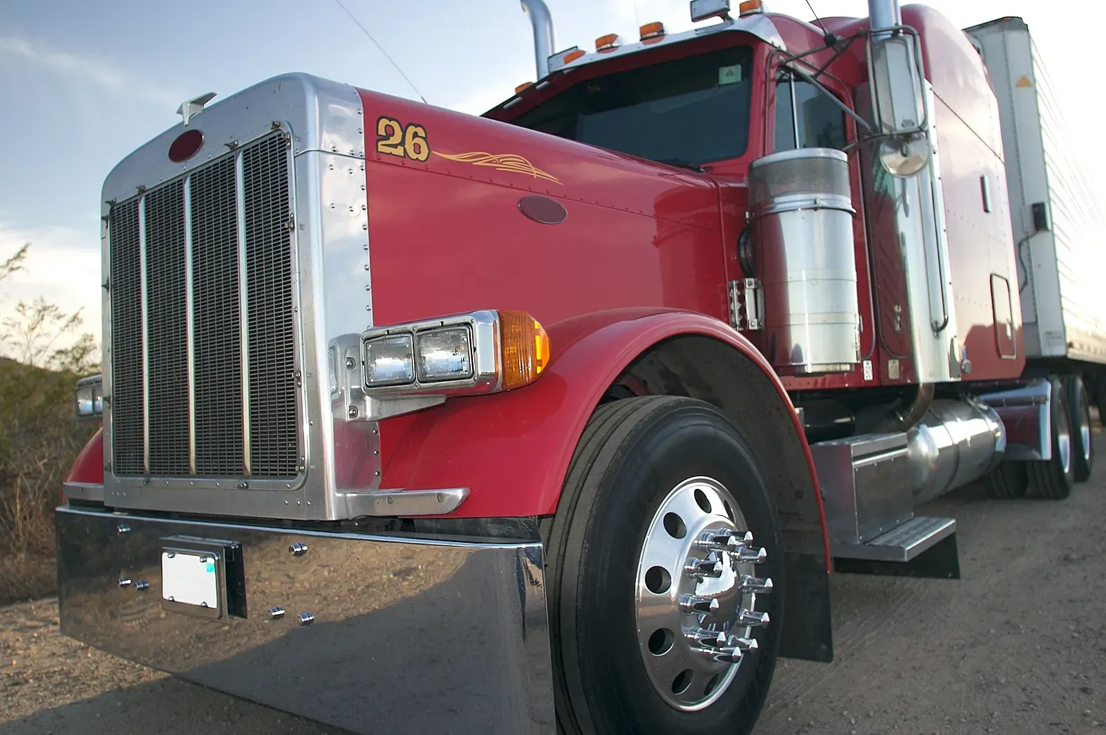 Red semi-truck parked outdoors, shown from the front-left side.