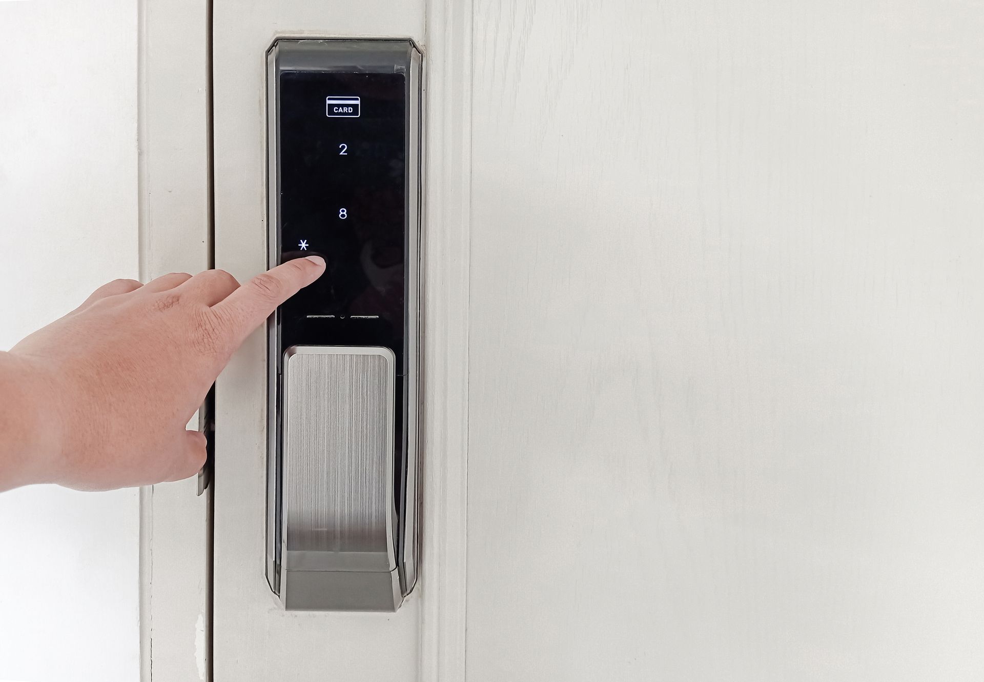 Hand using smart lock keypad to lock and unlock home door for security system.