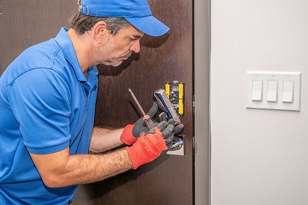 Experienced locksmith performing non-destructive lock repair on a residential door.