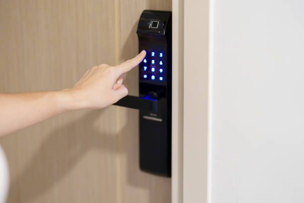 Smart lock digital keypad being pressed manually to lock or unlock a door.