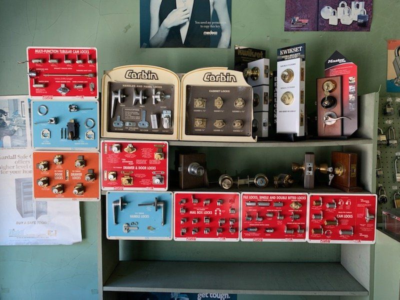 A shelf full of different types of door knobs and locks