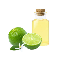 Una botella de aceite de color lima junto a dos limas, una entera, otra partida por la mitad y una flor de tilo.