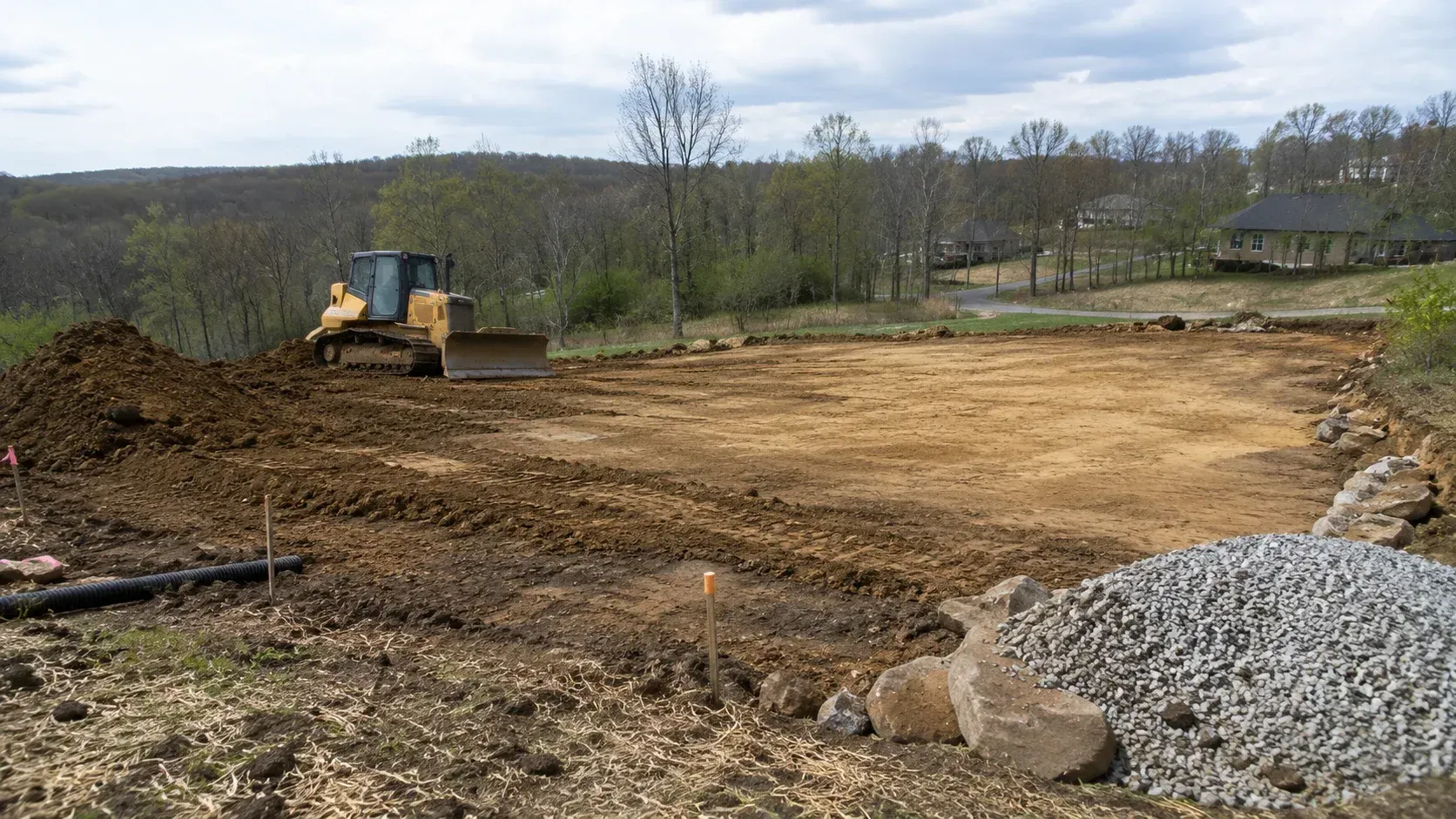 Yellow bulldozer grading soil: how much does it cost to excavate a building pad.