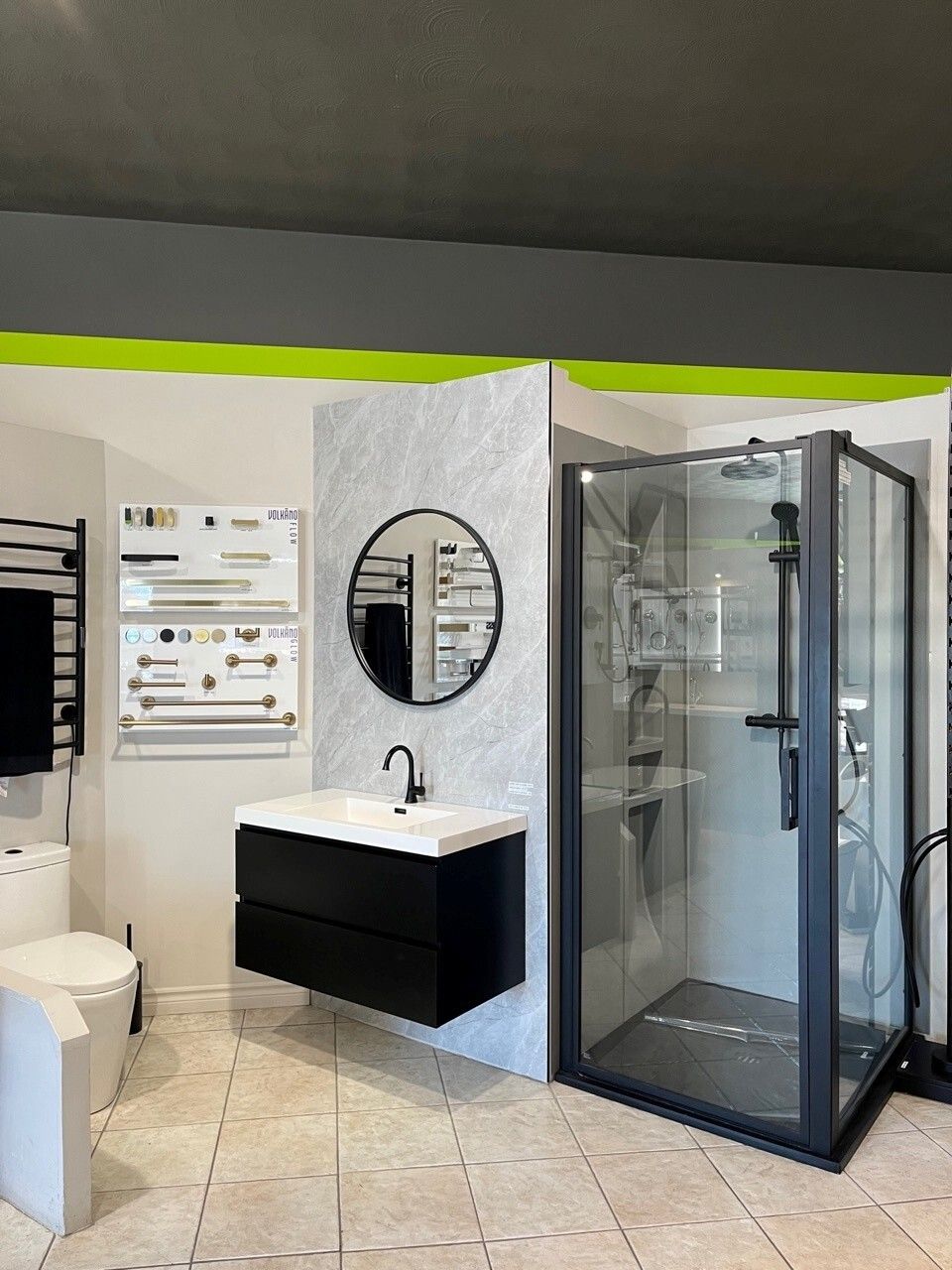 Salle d'exposition de salle de bains moderne avec meuble-lavabo, miroir rond, toilettes et cabine de douche en verre