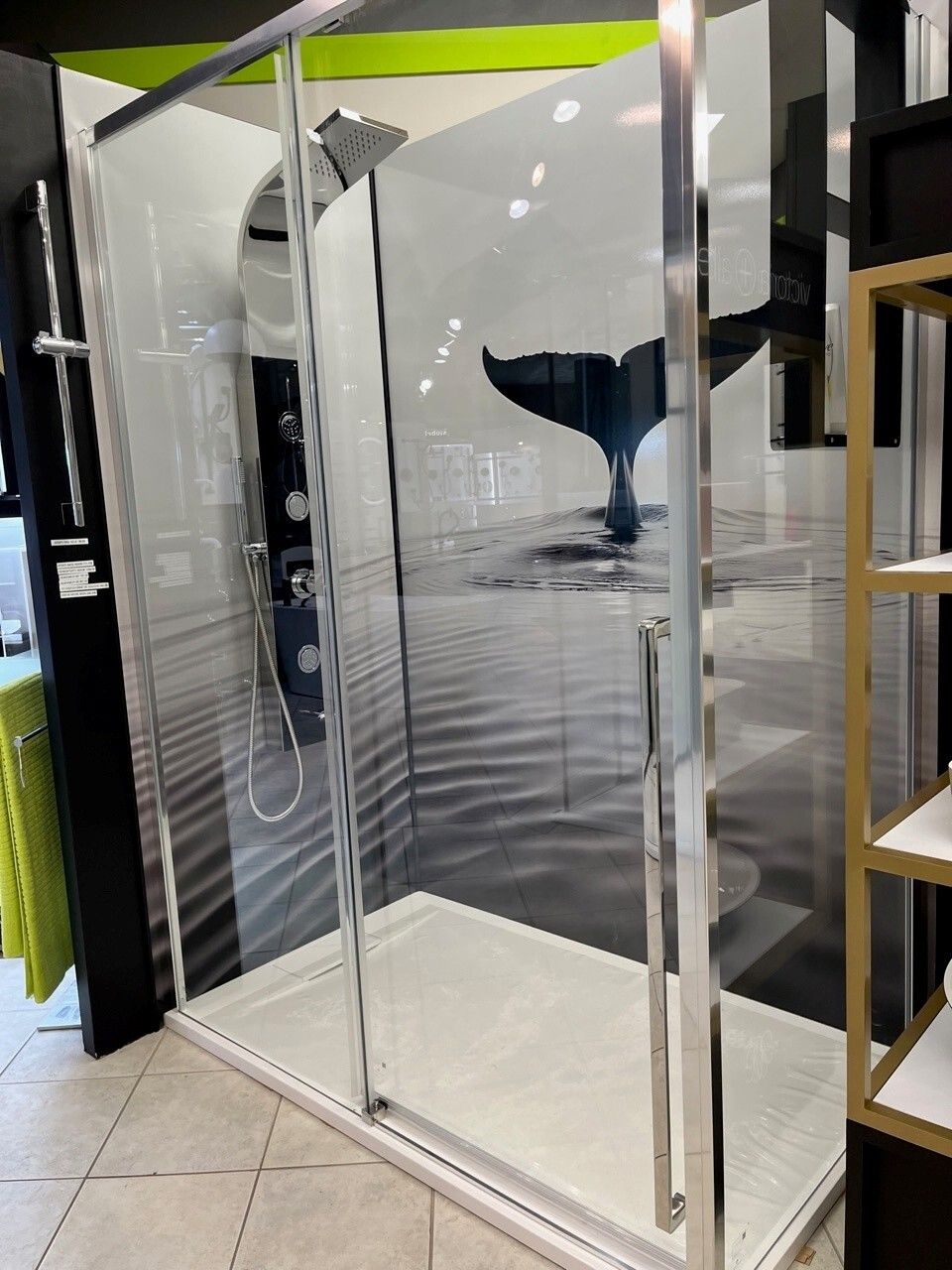 Cabine de douche en verre avec panneaux transparents et porte à charnières dans un espace showroom