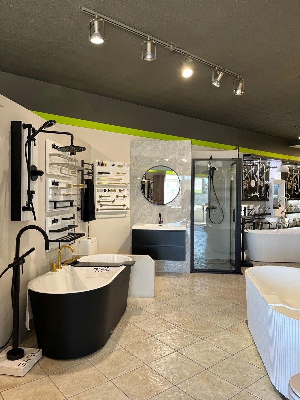 Salle d'exposition de salles de bains modernes avec baignoire îlot, meuble-lavabo, miroirs et douche à l'italienne