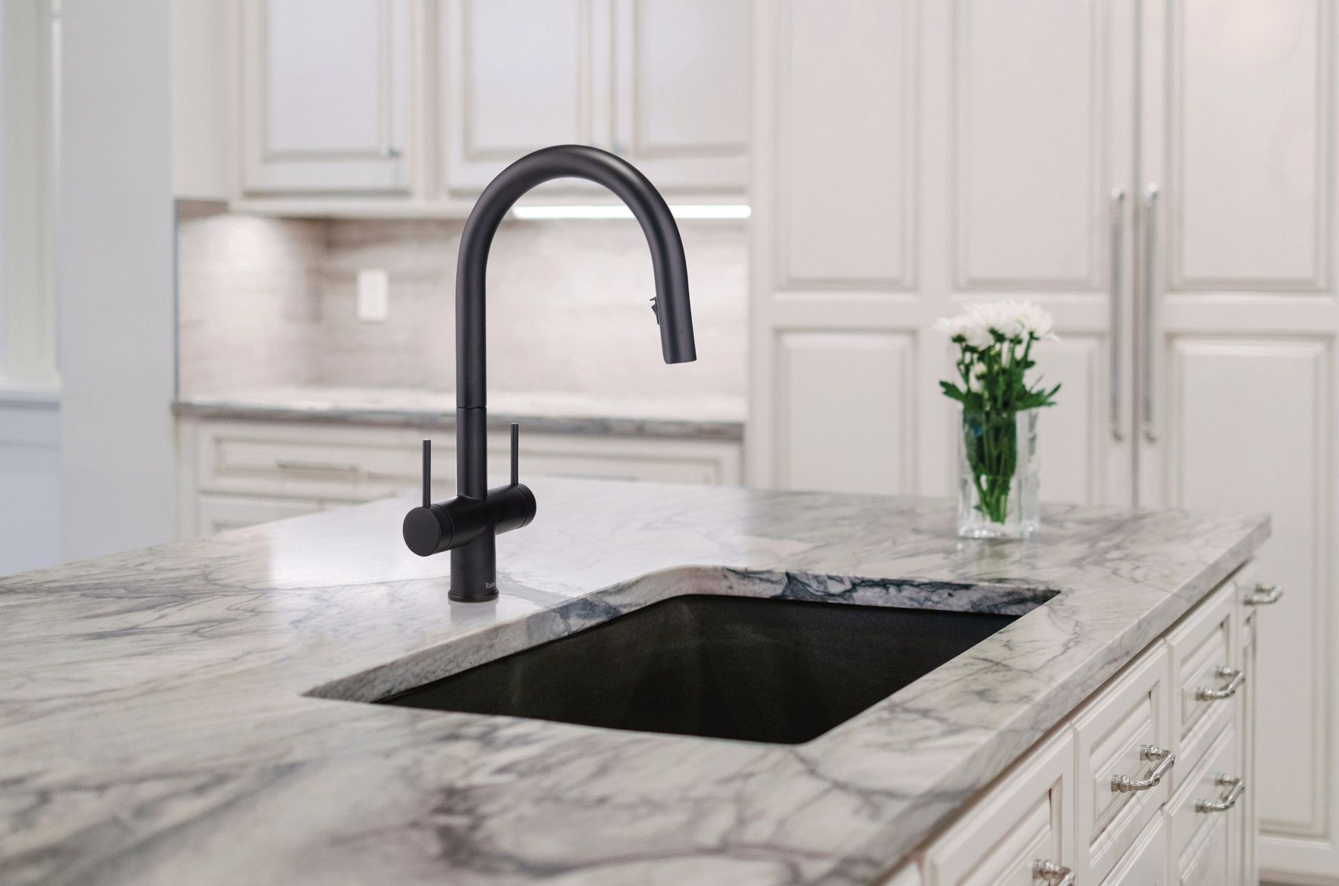Lavabo de salle de bain avec robinet doré, comptoir blanc, miroir et objets décoratifs.