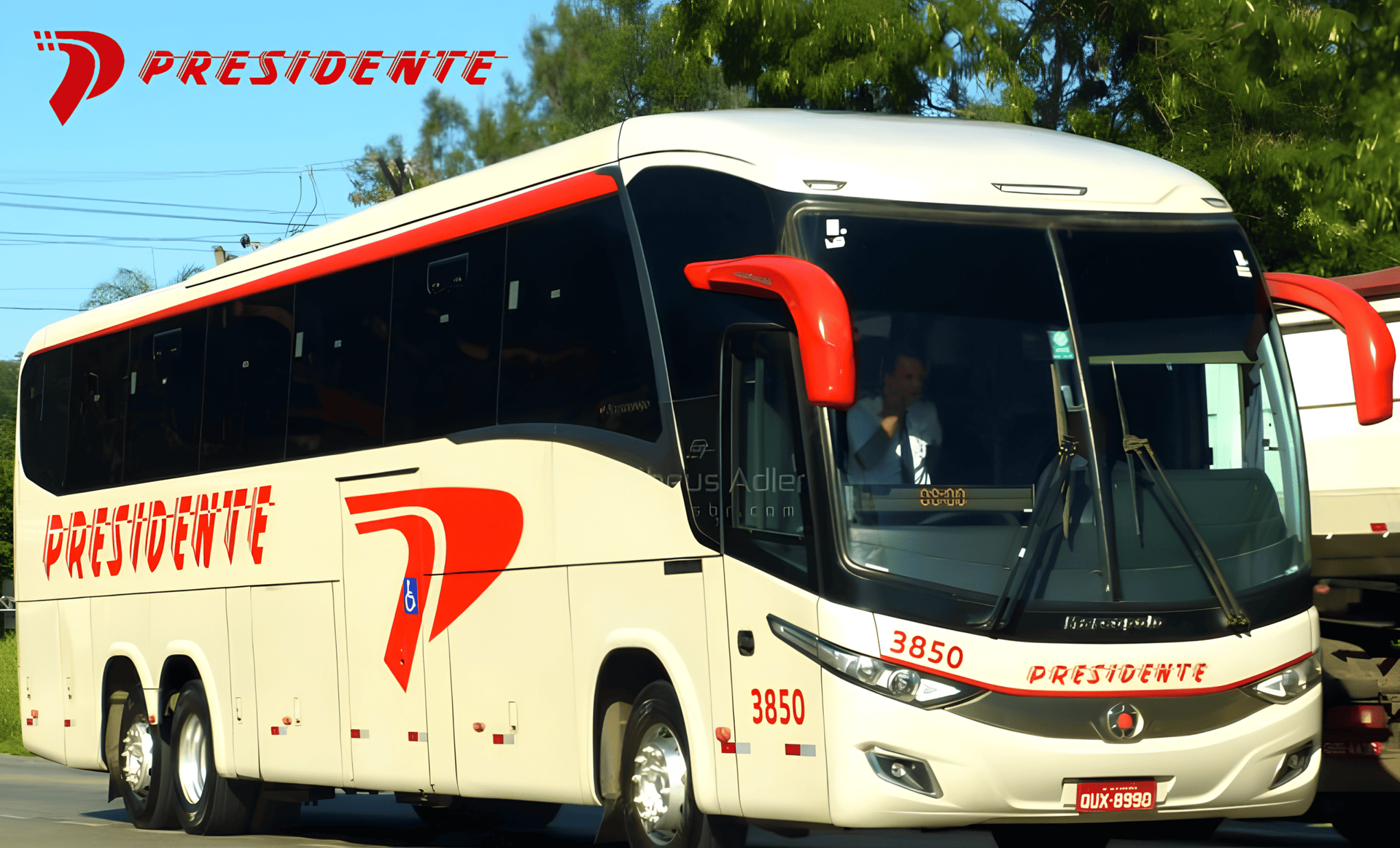 Ônibus de passageiros branco e vermelho trafegando em uma estrada sob um céu azul.