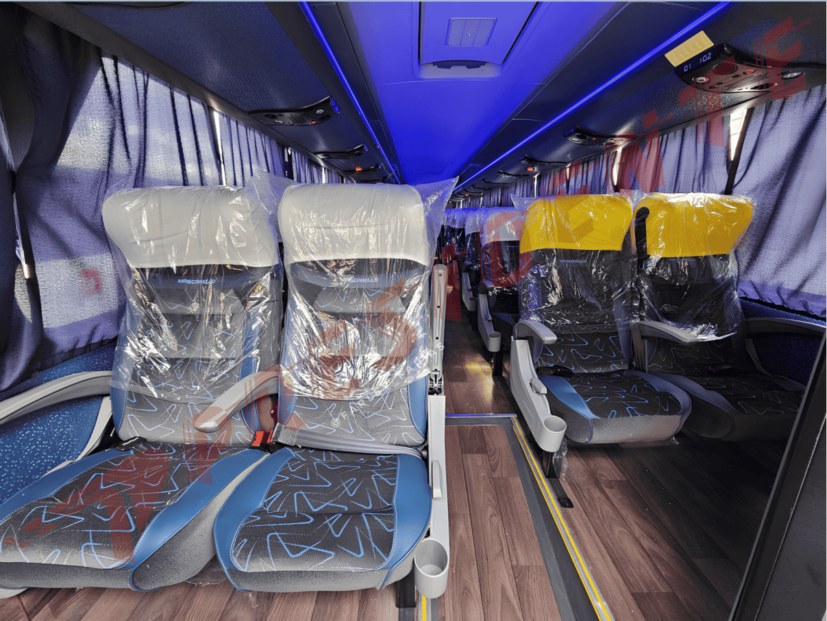 Interior de ônibus vazio com assentos cobertos de plástico e luzes azuis no teto.