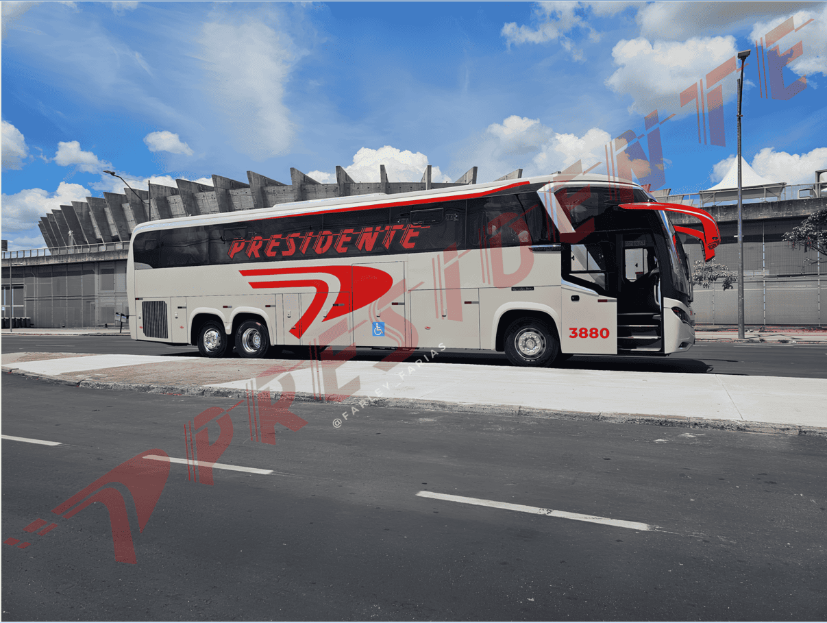 Ônibus de turismo branco e vermelho estacionado em frente a um estádio sob um céu azul.