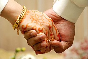 A man and a woman are holding hands with henna on their hands.