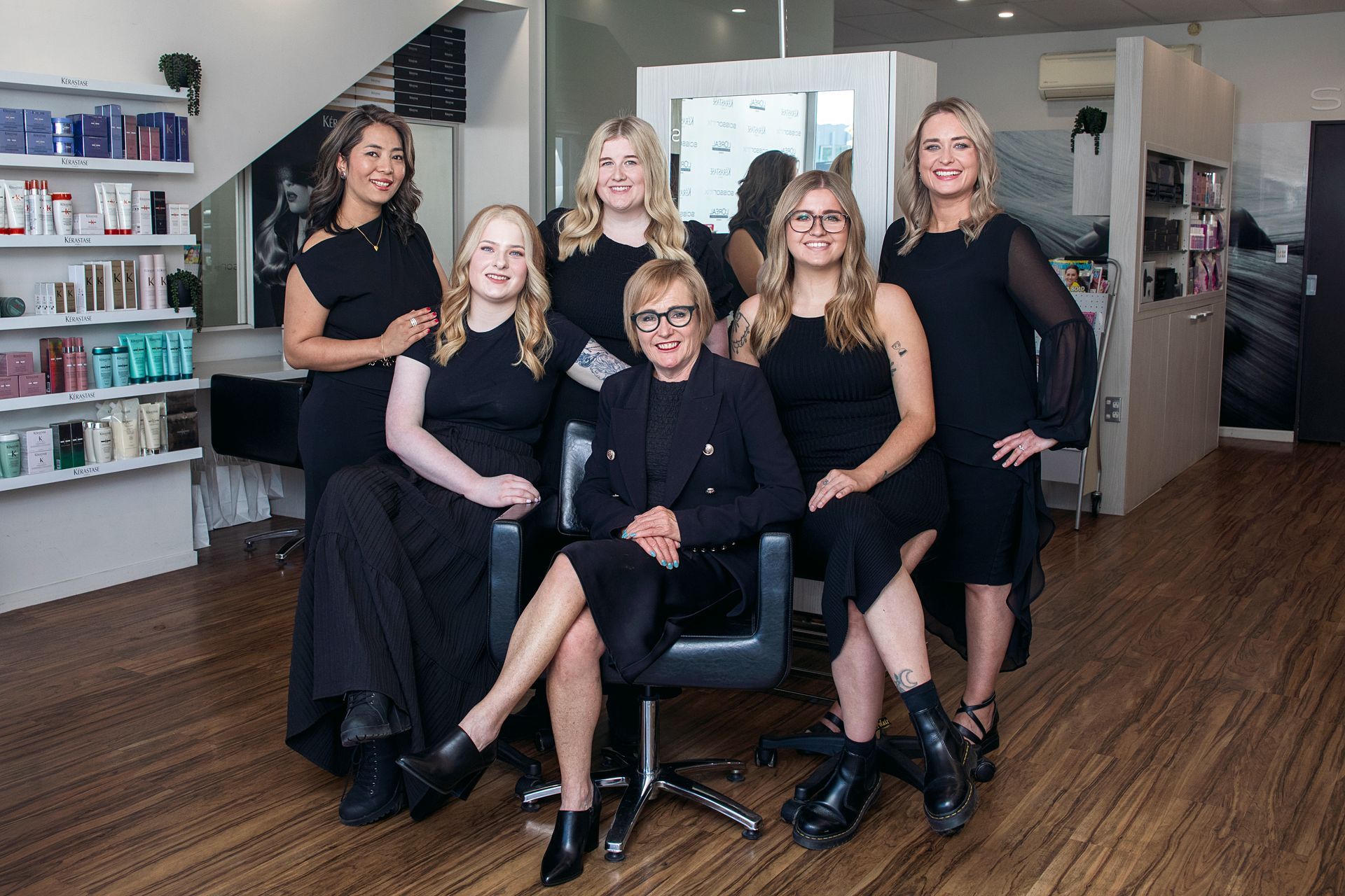 A group of women are posing for a picture in a salon.