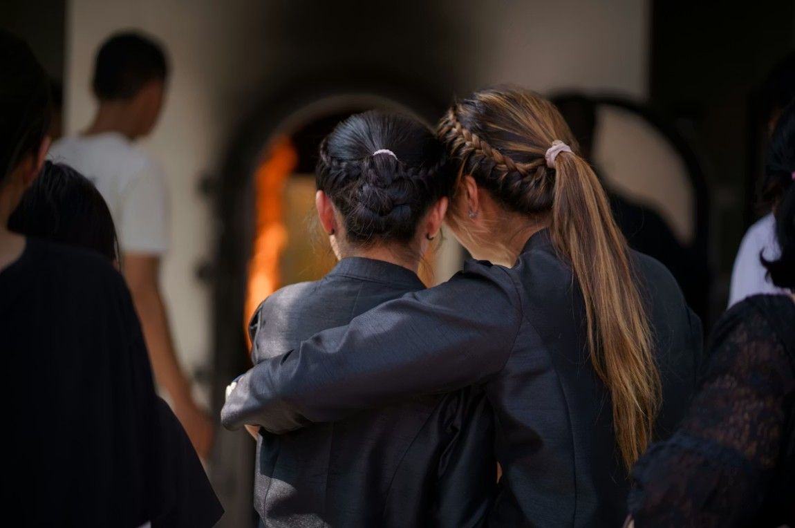Family members embracing at a memorial service, reflecting local care you can count on in Hingham, MA funeral and cremation services