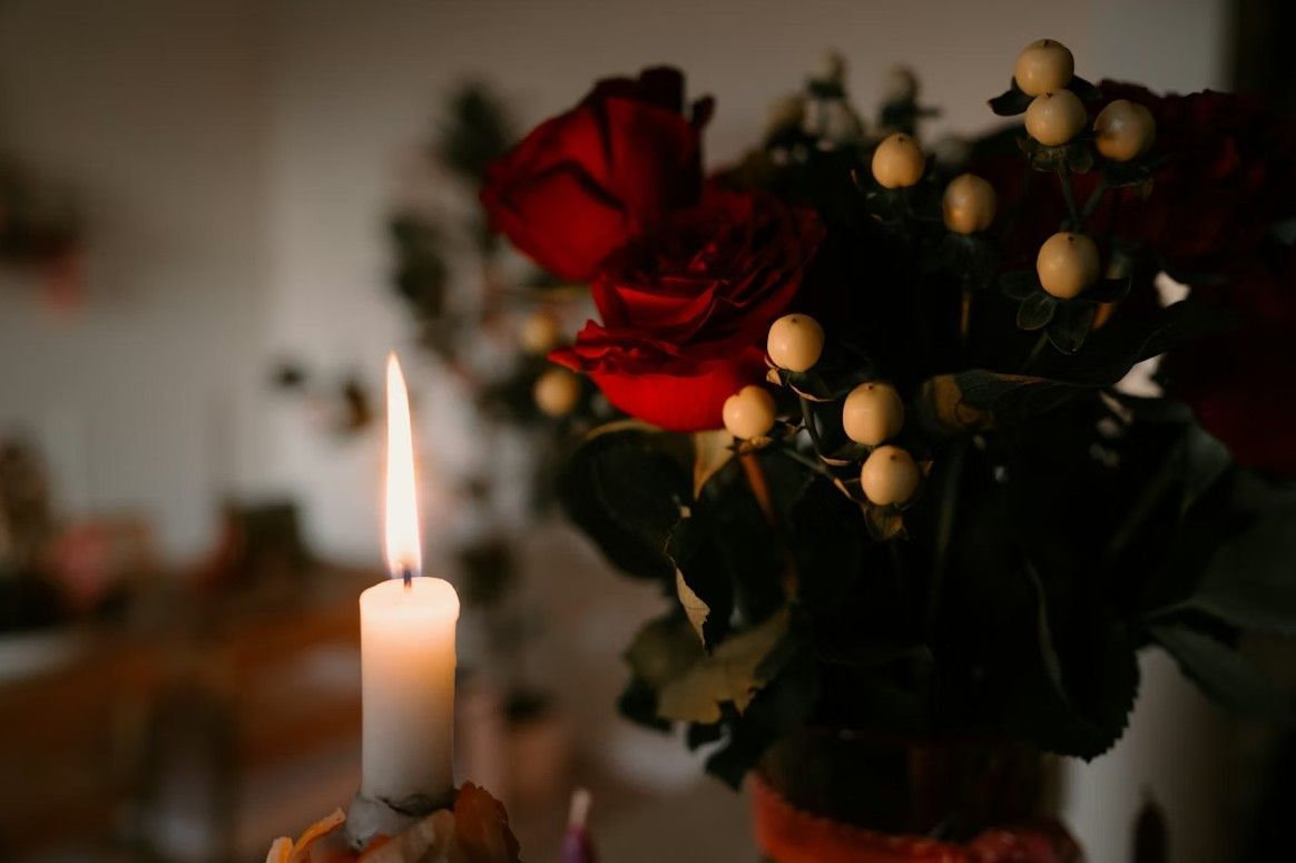 Memorial candle and red roses symbolizing remembrance and comfort for Quincy, MA funeral and cremation services