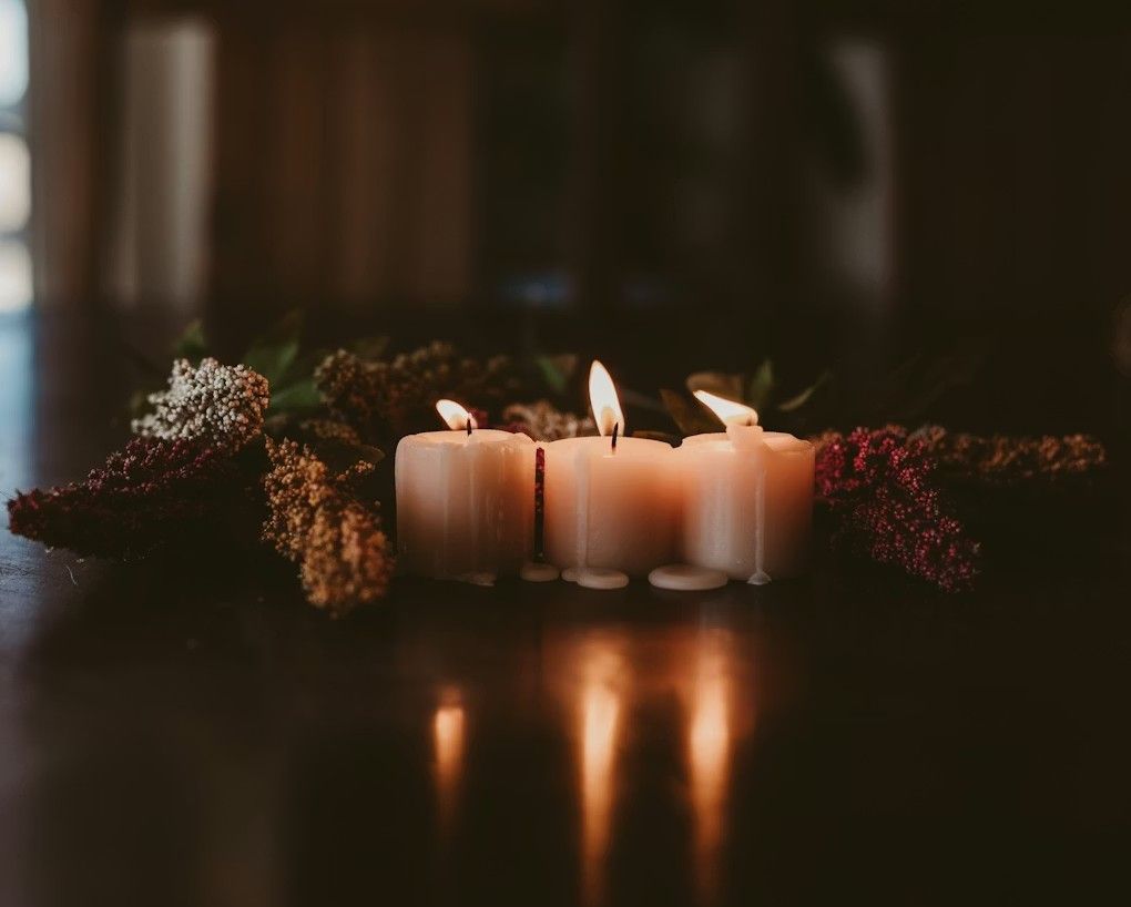 Memorial candles and floral arrangement symbolizing comfort and remembrance for Weymouth, MA funeral and cremation services