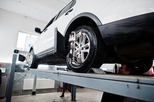White van lifted up in garage to receive ADAS Calibration | Euro Auto Tech & Smog
