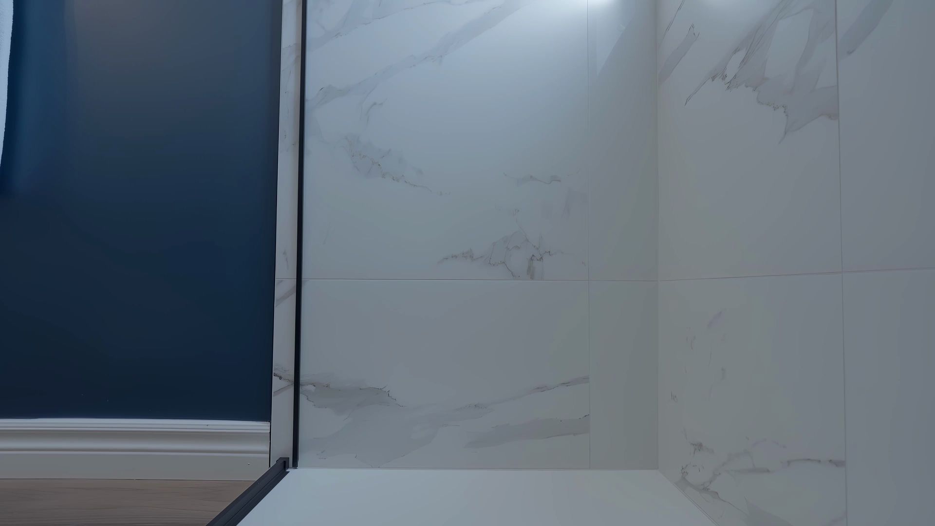 A bathroom with a walk in shower and a blue wall.