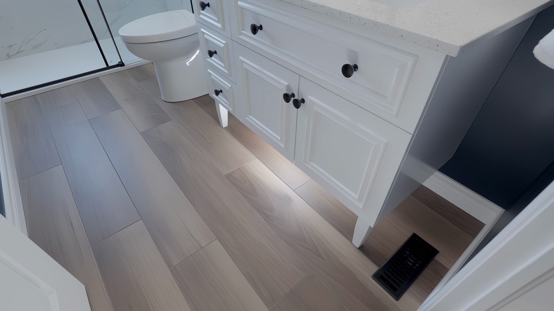 A bathroom with a toilet , sink , and cabinets.