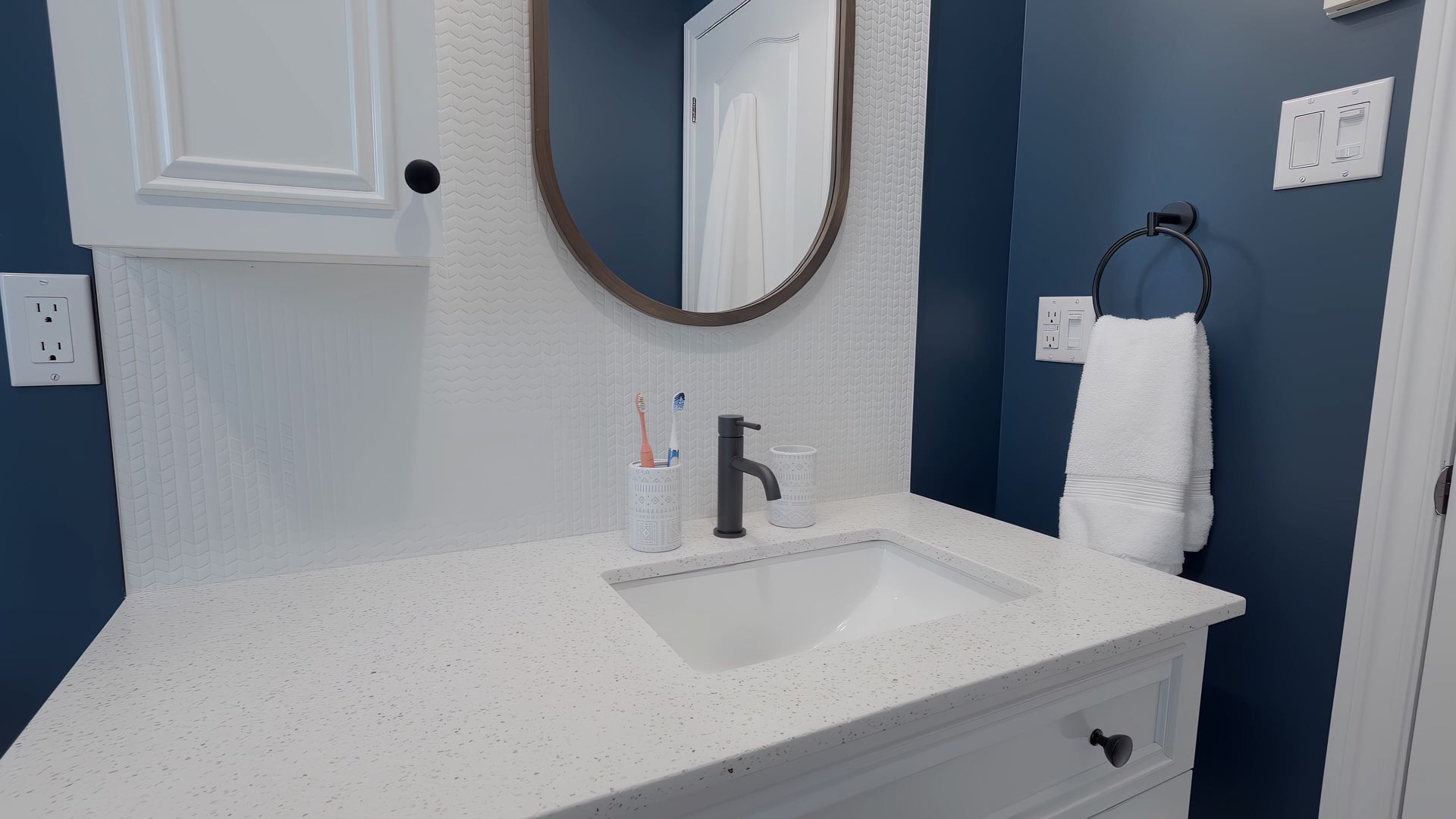 A bathroom with a sink , mirror and towel rack.
